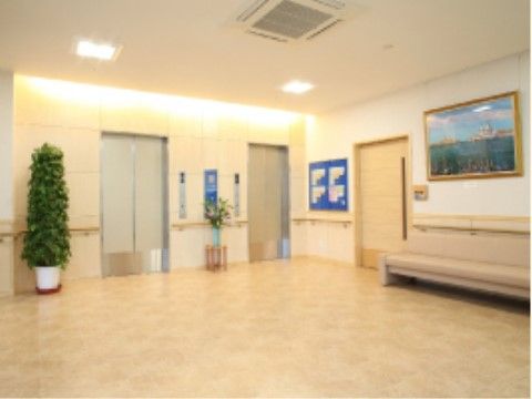 施設案内図が掲示され、長ベンチが置かれているエレベーター乗降口付近