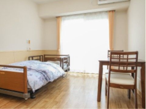 介護用ベッドやテーブルが置かれた居室。呼び出しボタンが備え付けられており、夜間も安心して過ごすことができる。
