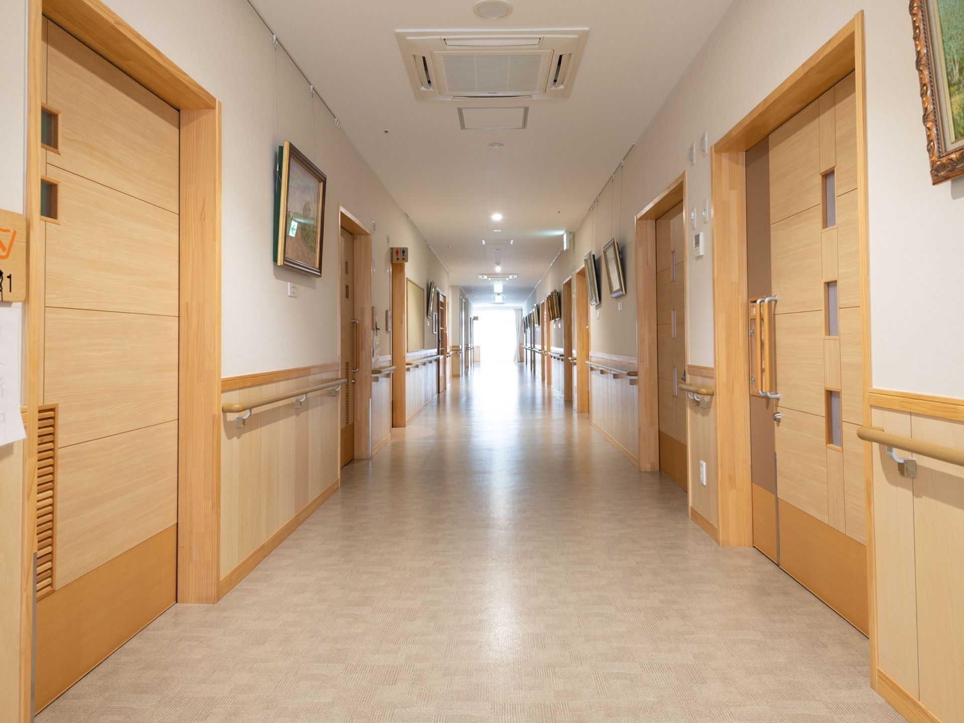 壁に手すりを設けた廊下がまっすぐ伸びている。両側に並ぶ各部屋の扉はすべてスライド式になっている。ところどころに絵画が飾られている。