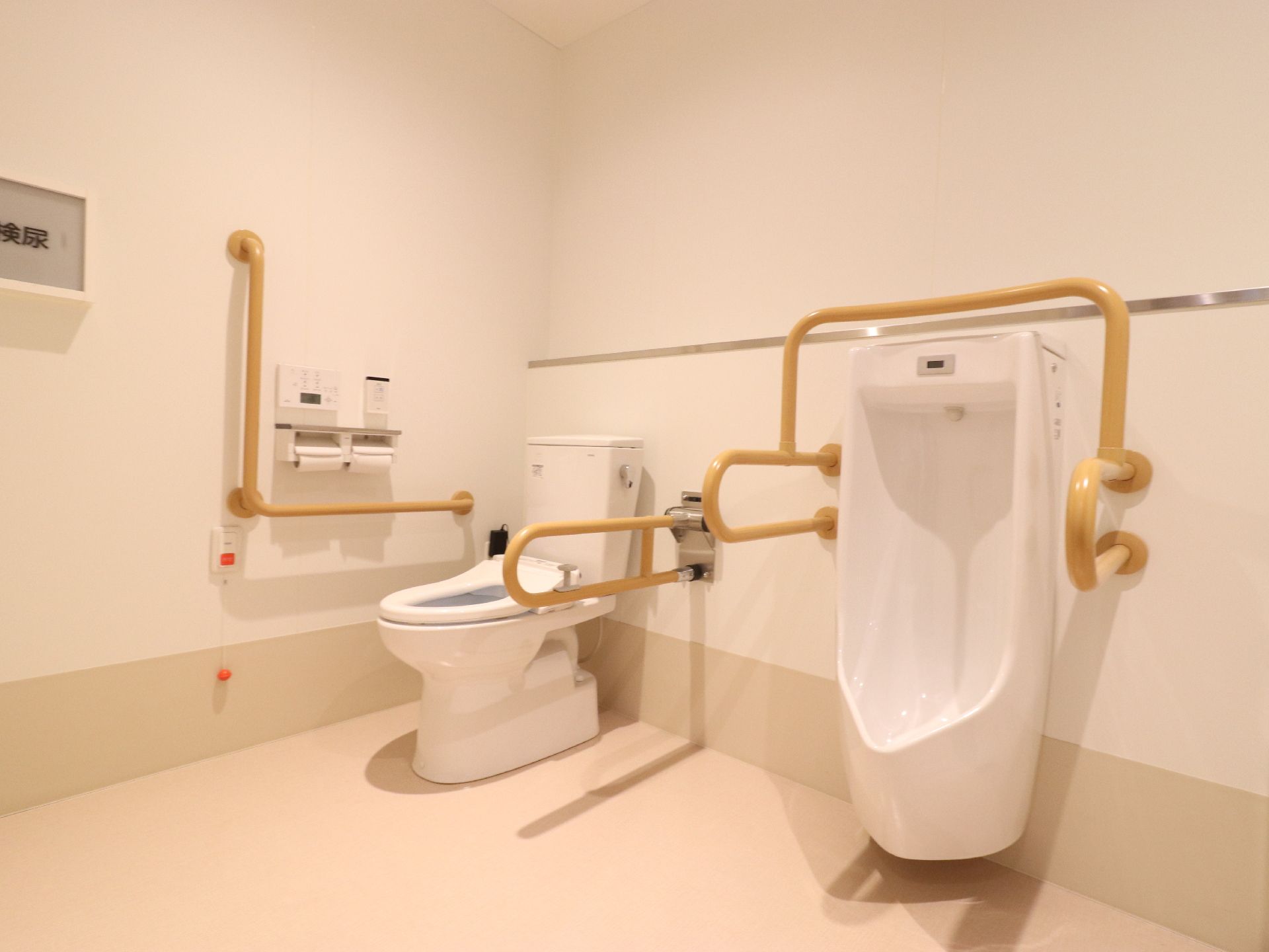 洋式トイレがある。壁に緊急呼び出しのベルが取り付けてある。紐が長く設定してあるので、腰かけた状態でも利用できる。