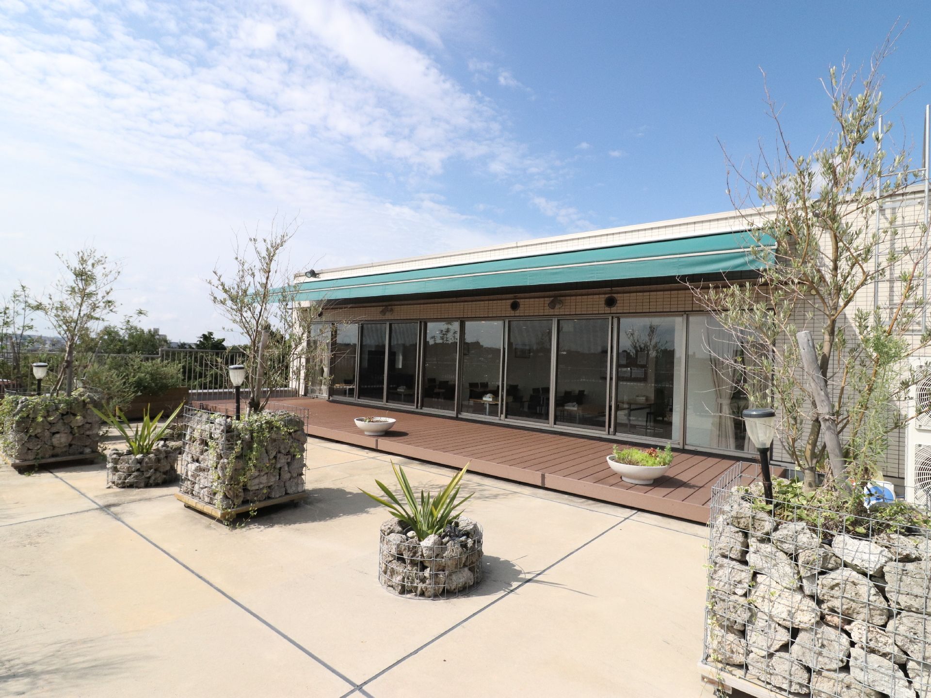 食堂の隣に広々とした屋上庭園がある。ウッドデッキも完備されている。花壇が数か所あり草木が美しく植えられている。