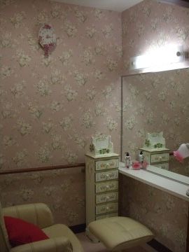 大きな鏡の前に、脚置き台付きの椅子が置かれているフットケアサロン