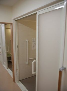 取っ手のある引き戸タイプの入口で、入ってすぐの所に手すりが設置されている浴室