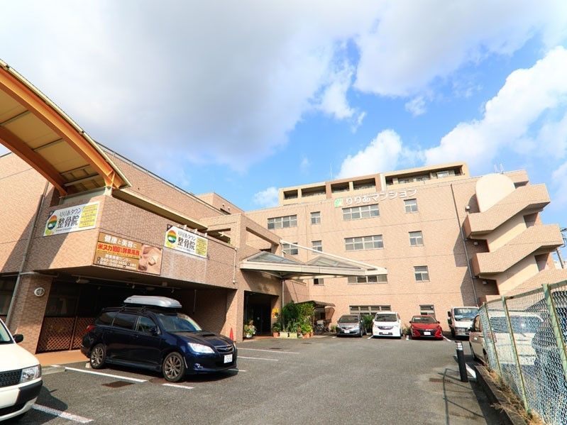 レンガ色の外壁の５階建の建物。マンションの様な外観である。４階の窓の上には大きく施設名が掲げられている。