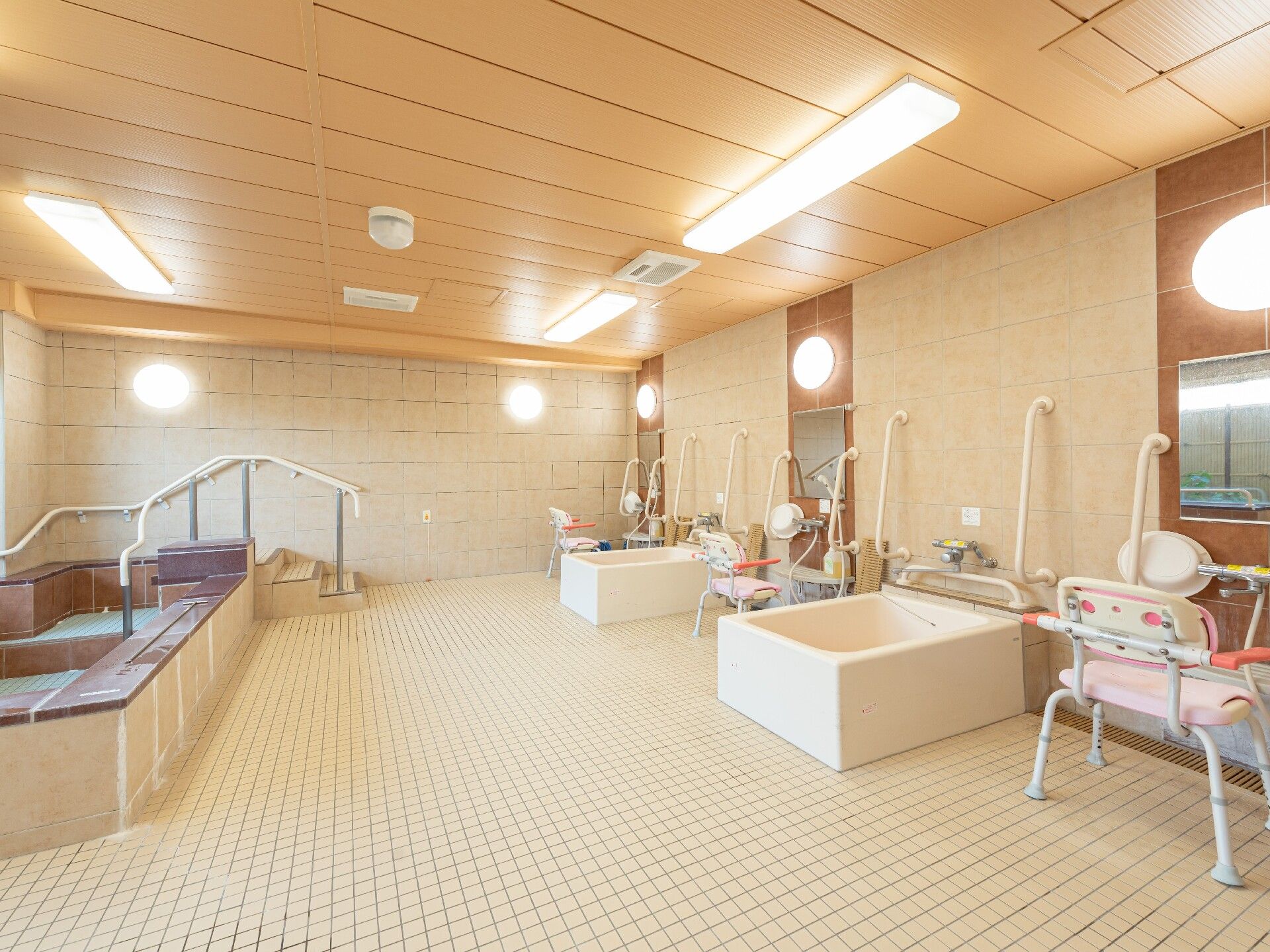 明るい清潔感のある空間で、大きな浴槽と個浴が2個ある。車いすが数台乗り入れても余裕があるほどの広さがある。