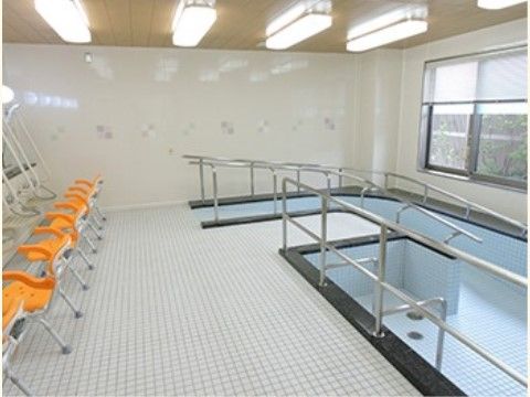 手すり付きの緩やかなスロープで出入りできる掘り込み式の大きな浴槽