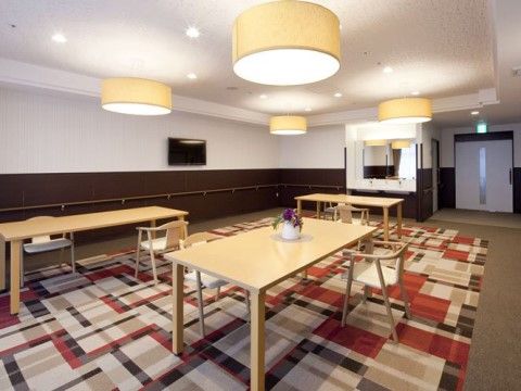 各テーブルに、椅子が向かい合わないように置かれている食堂