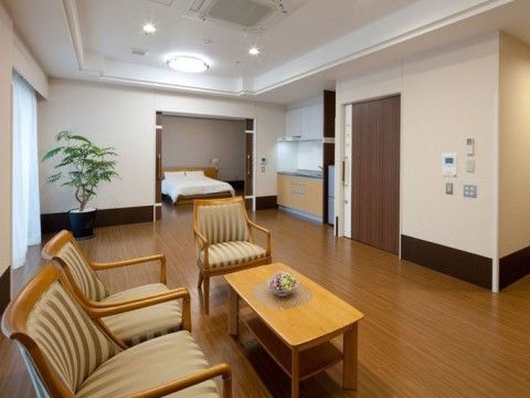 手前に応接セット、奥の方にベッドが置かれている、広いスペースのある居室