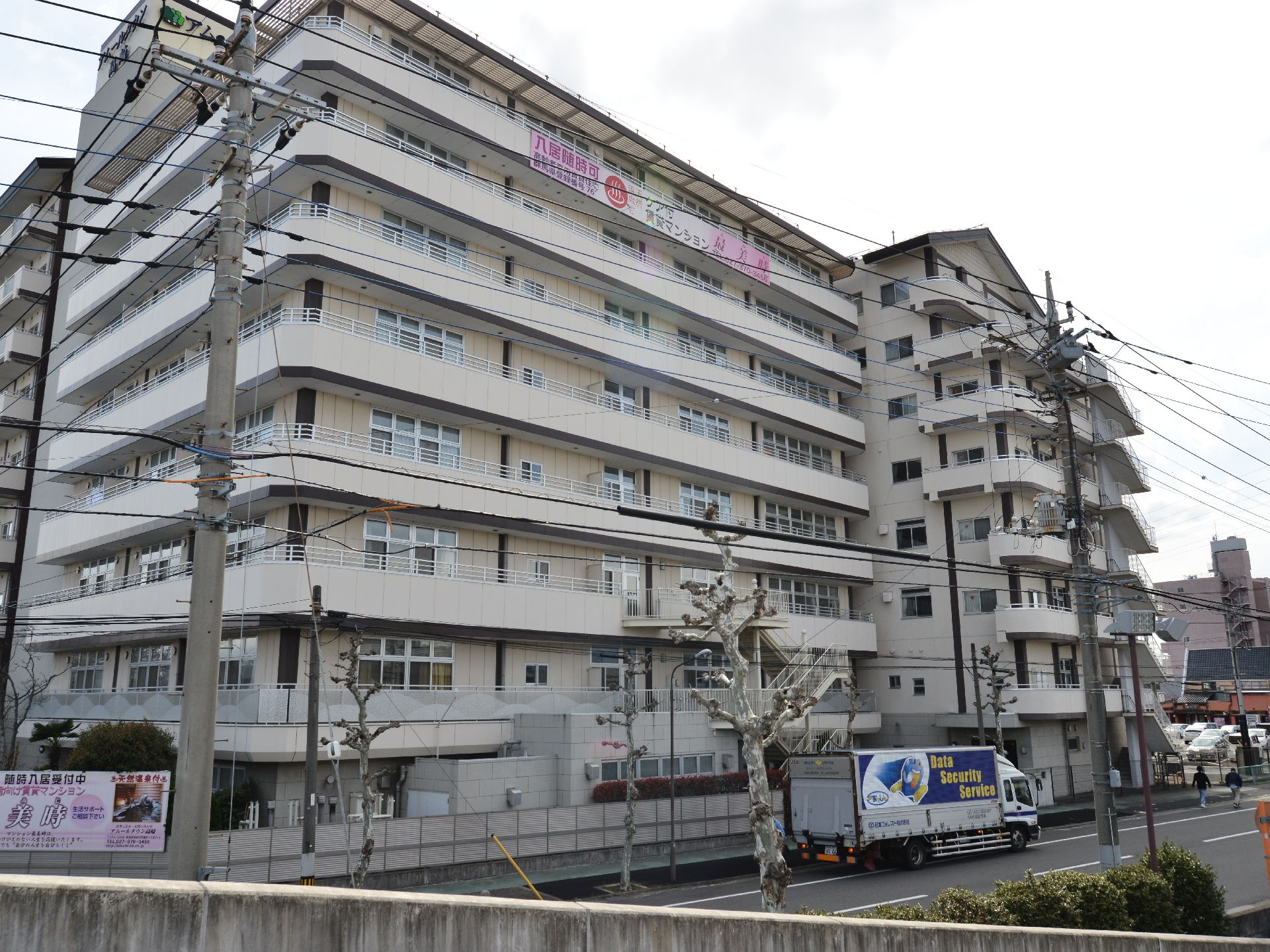 施設外観はマンションのような姿を有しており、8階建ての建物となっている。施設前は道路になっていてトラックが通っている。