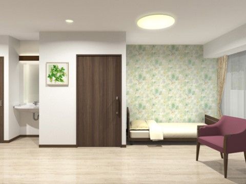 ベッド横の壁に薄緑色の壁紙が貼られている、すっきりとした居室