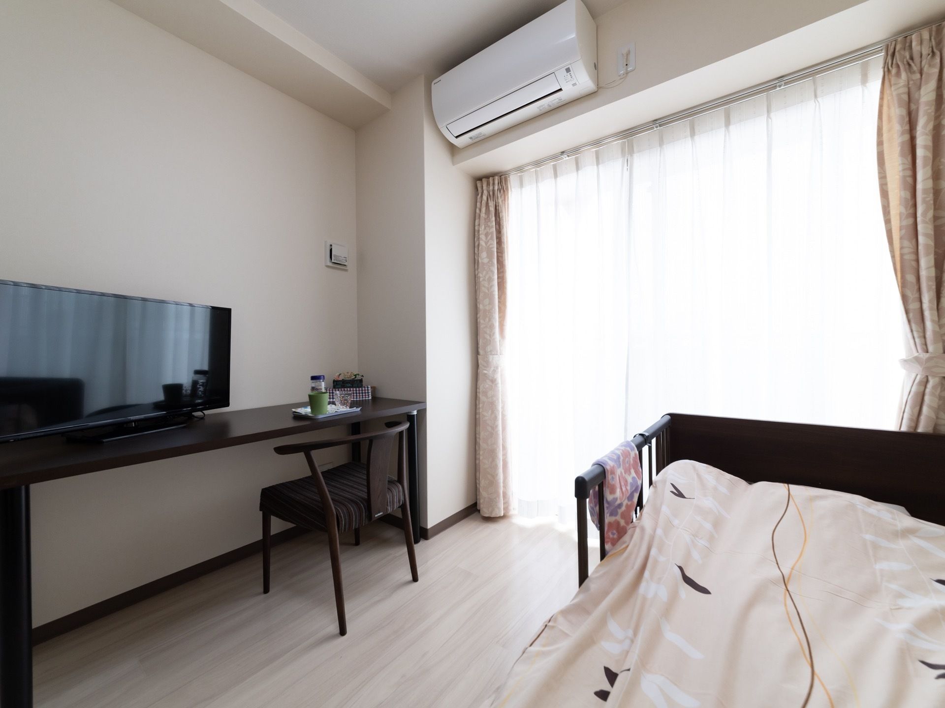 大きな窓から光が入る明るい居室である。エアコンを設置しており、１年を通して快適に過ごすことができる。