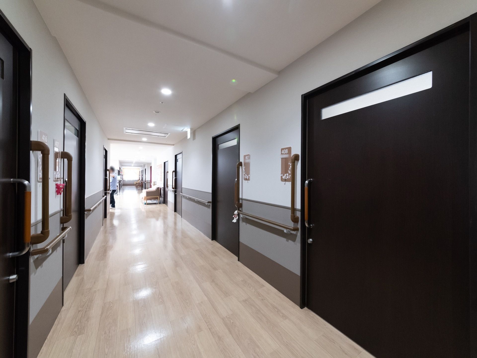 落ち着いた雰囲気の廊下である。壁には手すりを設置しており、安全に移動することができる。幅が広く、車椅子をご利用の方も安全に移動できる。