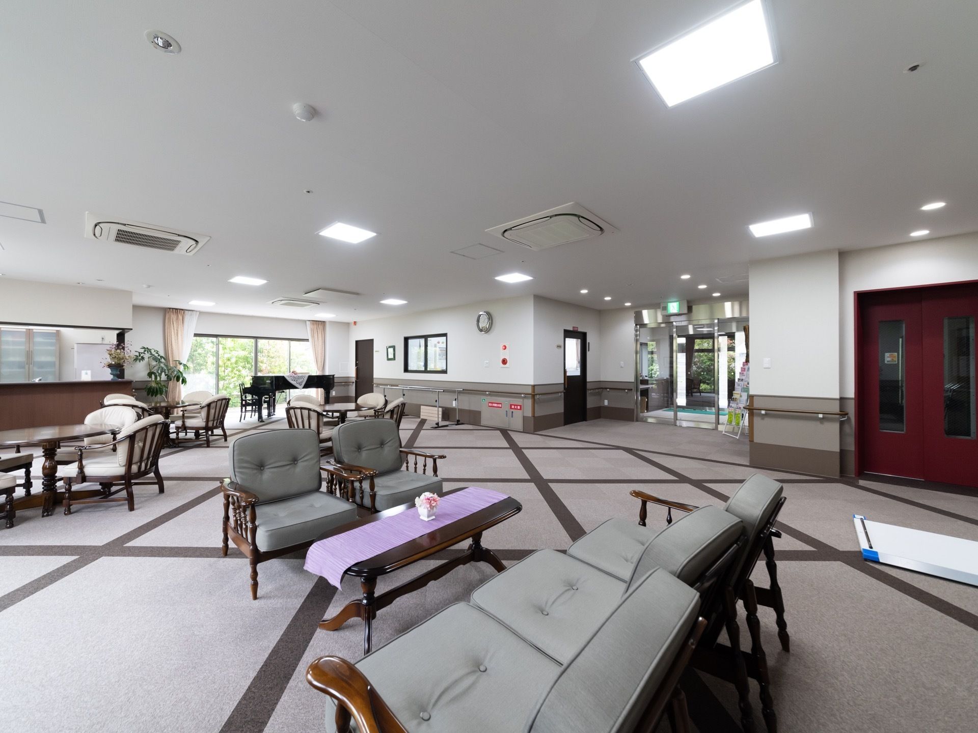 落ち着いた雰囲気の広々としたスペースである。窓から光が差し込み、ゆったりとソファでくつろぐことができる。奥にはピアノがある。