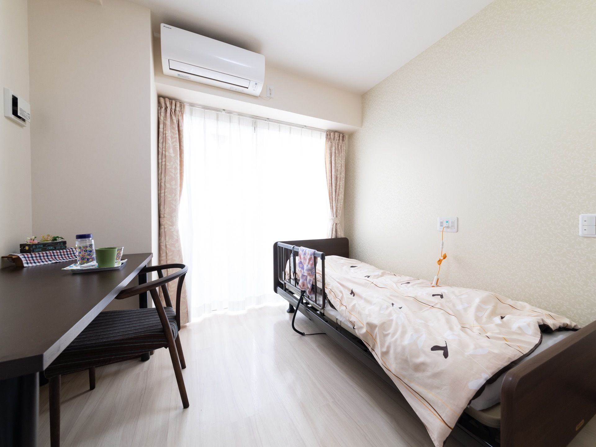 居室は明るく清潔感のあるスペースである。ベッド近くの壁にナースコールがあり、いざという時も安心である。