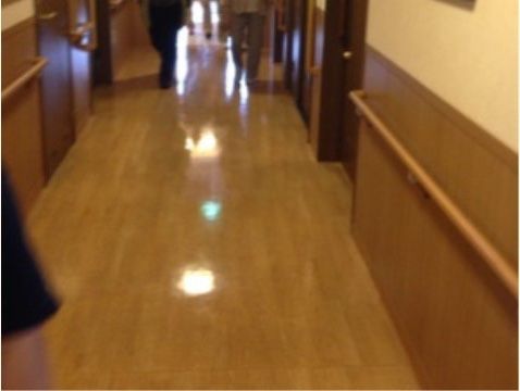 両側の壁には手すりが設けられている。フローリングの床はきれいに磨かれており、天井の照明が反射している。