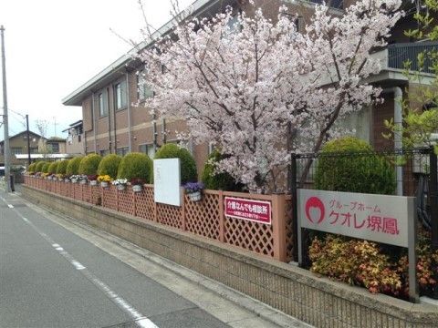 季節の花が満開に咲いている木のすぐ下に設置されている施設看板