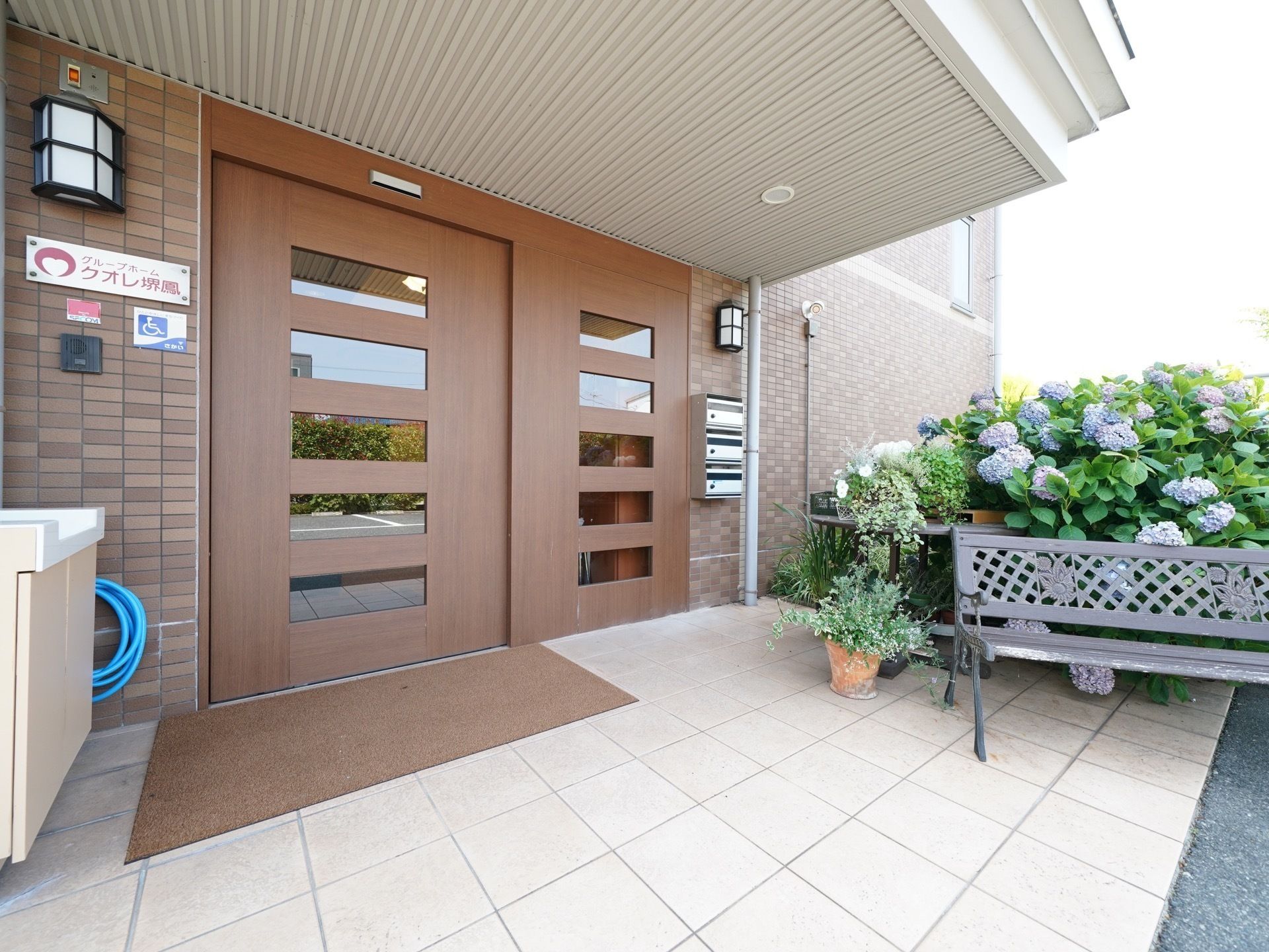 横方向に5枚のスリットガラスが入っている茶色の自動扉