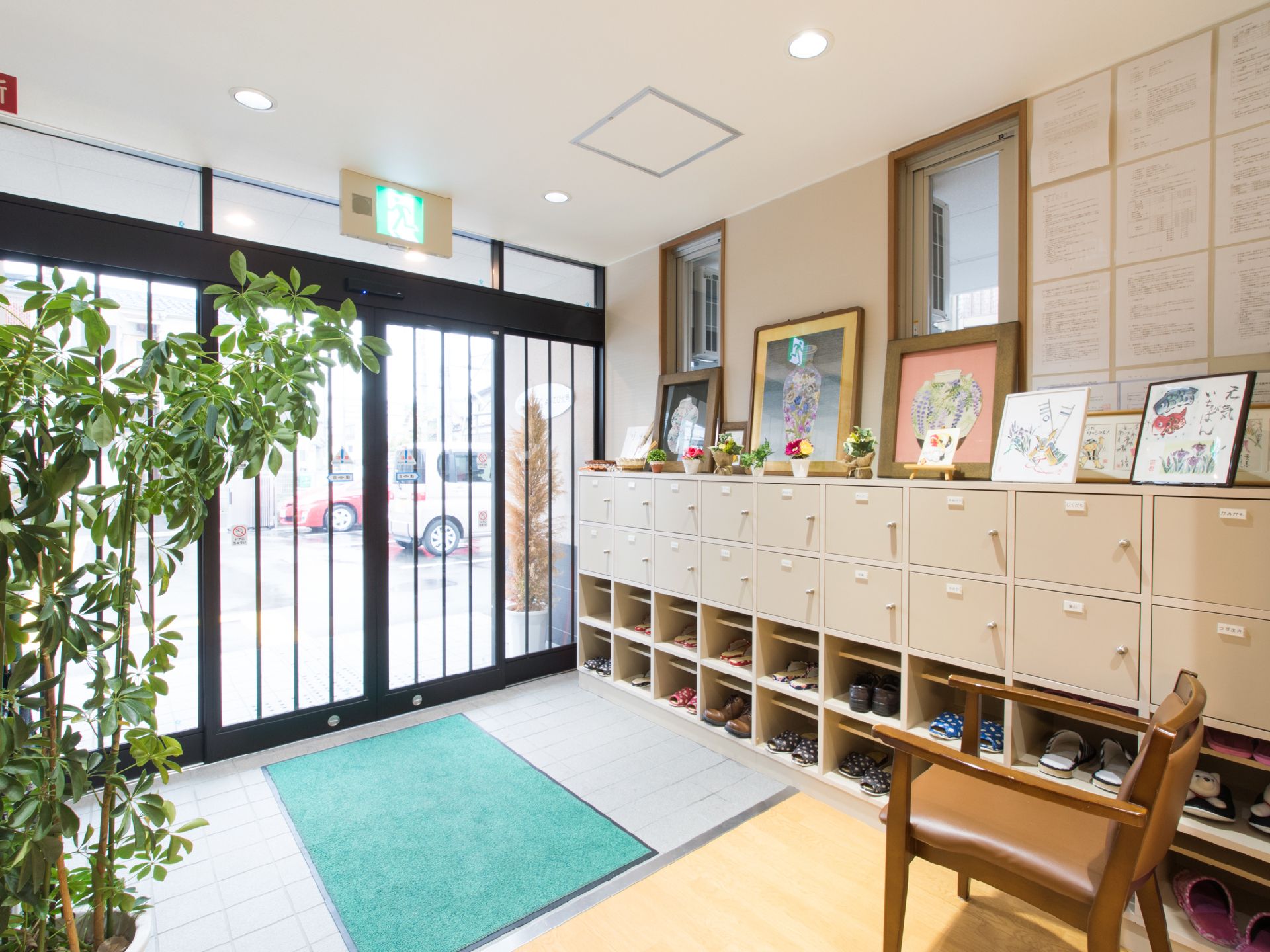 玄関には、下駄箱が備え付けられている。椅子もあり、靴の脱ぎ履きの時に利用できる。下駄箱の上には、絵や作品等が飾られている。