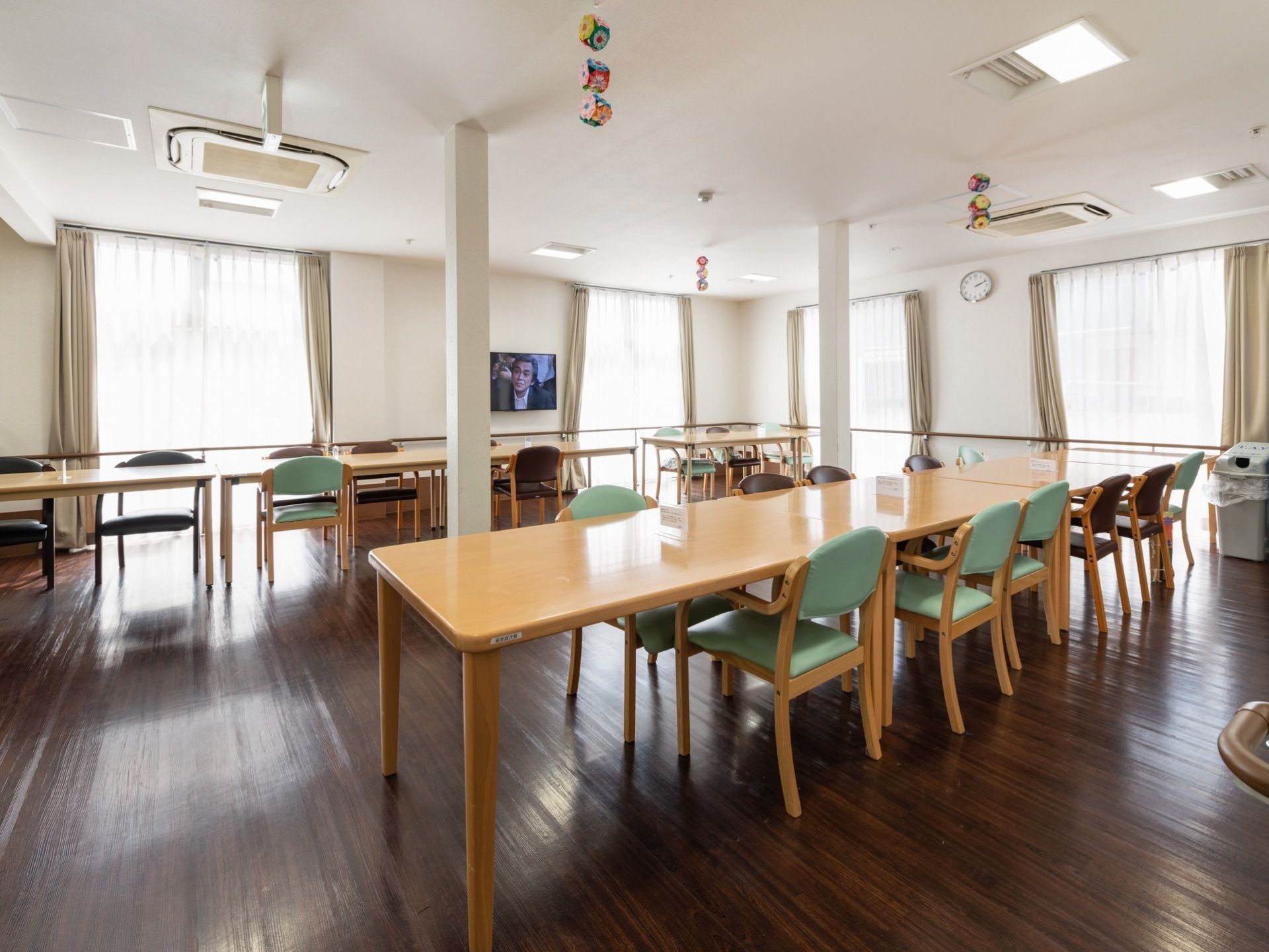 大きな窓がたくさんある明るいリビングで、中央の壁際にはテレビが設置してある。空調設備が完備されているので、いつでも快適な温度に保たれている。