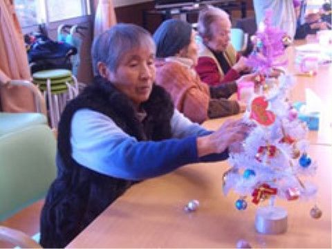テーブルに集まって、季節のイベントにちなんだ飾りつけを楽しんでいる入居者様たち