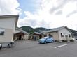 余裕のある敷地に平屋建ての施設である。自然豊かな環境で日当たり、通気などが良好である。駐車場もあり車が停められている。