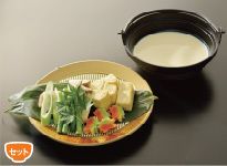 白いだしの入った鍋と、皿に盛り付けられた鍋の具材