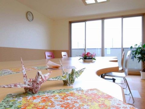 花柄の折り紙とそれを使って作られた折り鶴が置かれた机