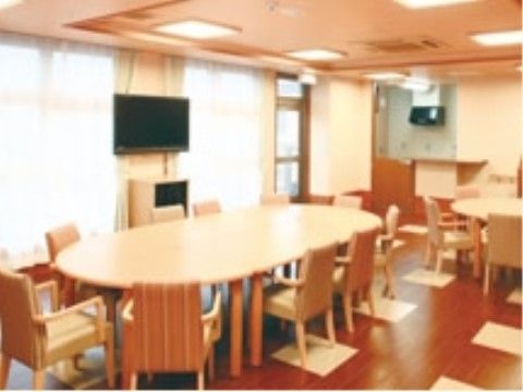 10人が座れる大きなテーブルがある、テレビ付きの食堂