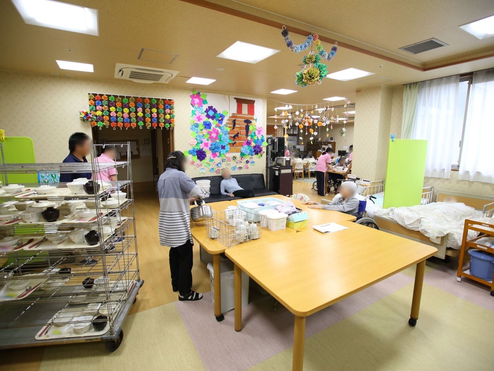 壁や天井に季節のレイアウトがされた食堂である。中央に設置されたテーブルにスタッフが食事を配膳する用意をしている。