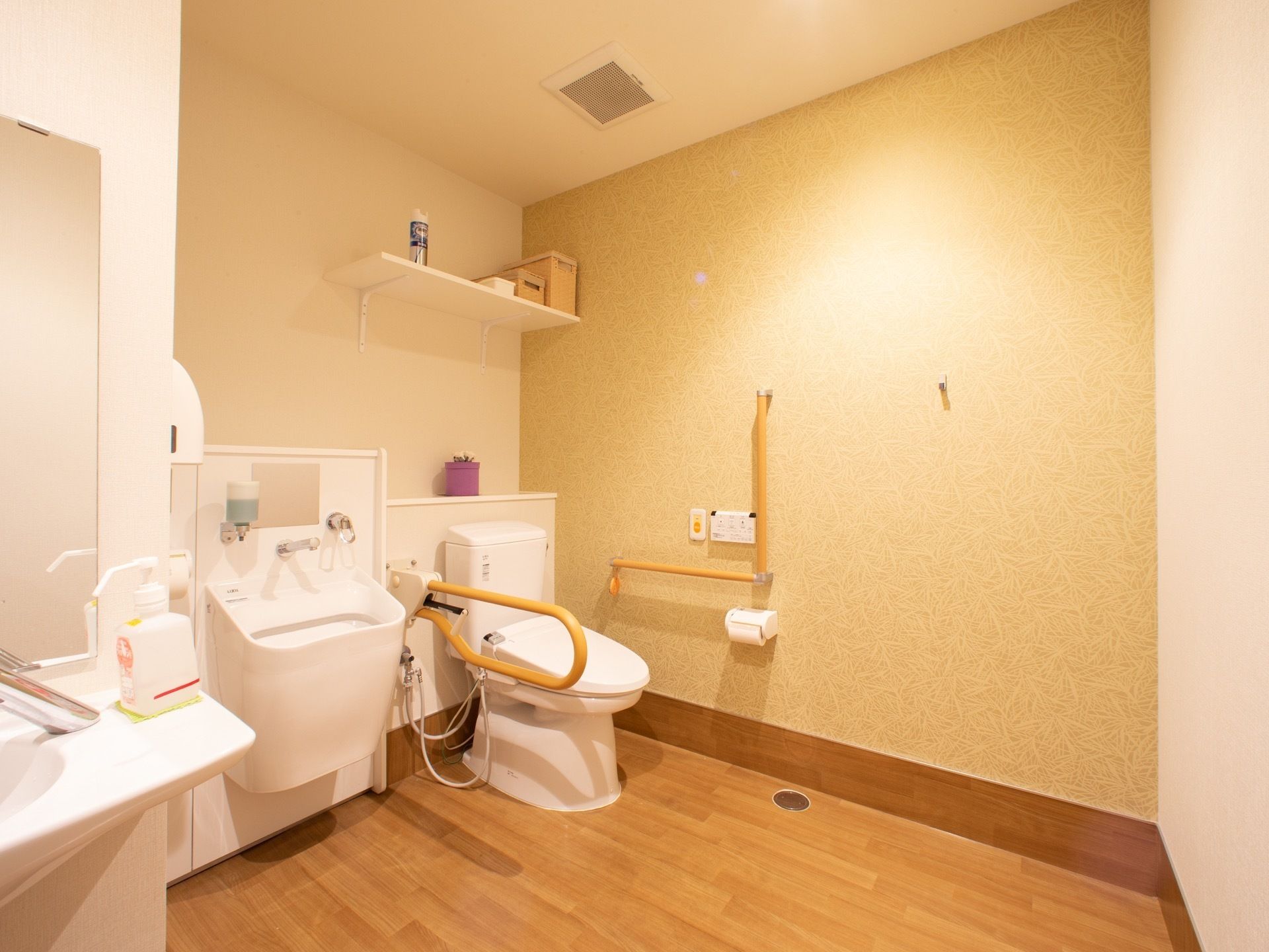 手すり付きのオストメイト対応の洋式トイレと、洗面台が付いた洗面所