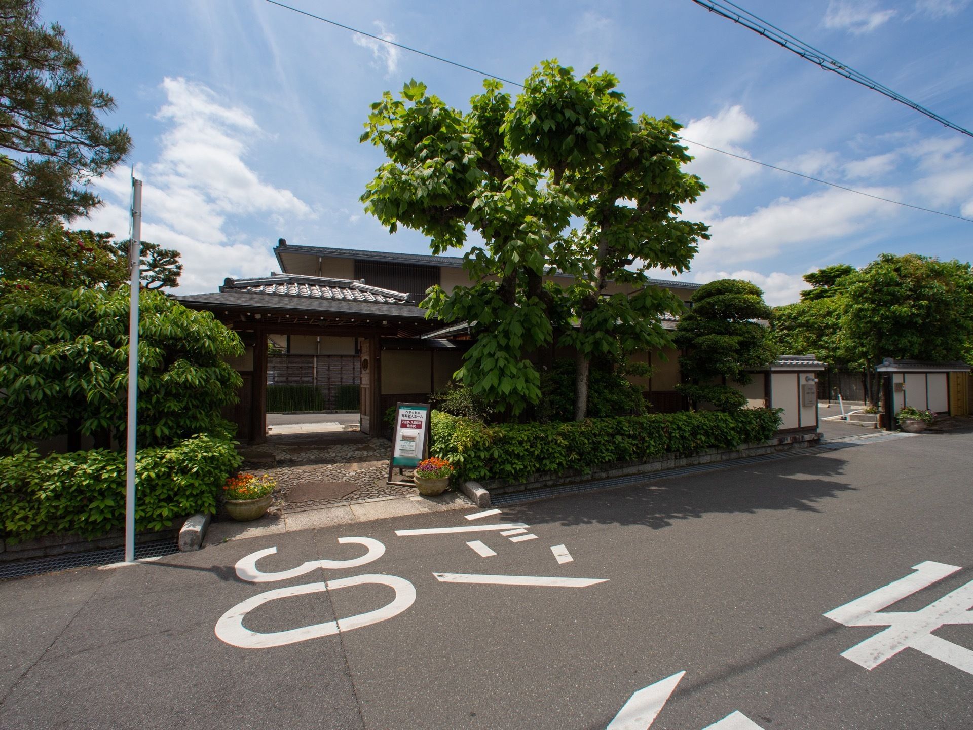 通りに面した、武家屋敷の風の日本建築の門と車両用出入口
