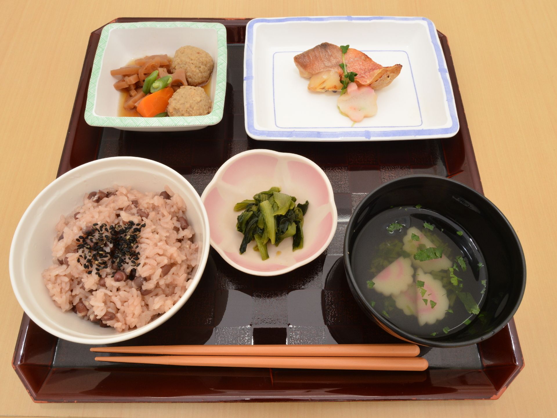 赤飯、肉団子と野菜の炊き合わせ、赤魚の煮付け。かまぼこの味噌汁、高菜といった栄養バランスに取れた献立。