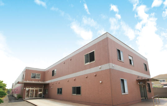 ホーム入口のゲートに取り付けられたピンク色の施設看板