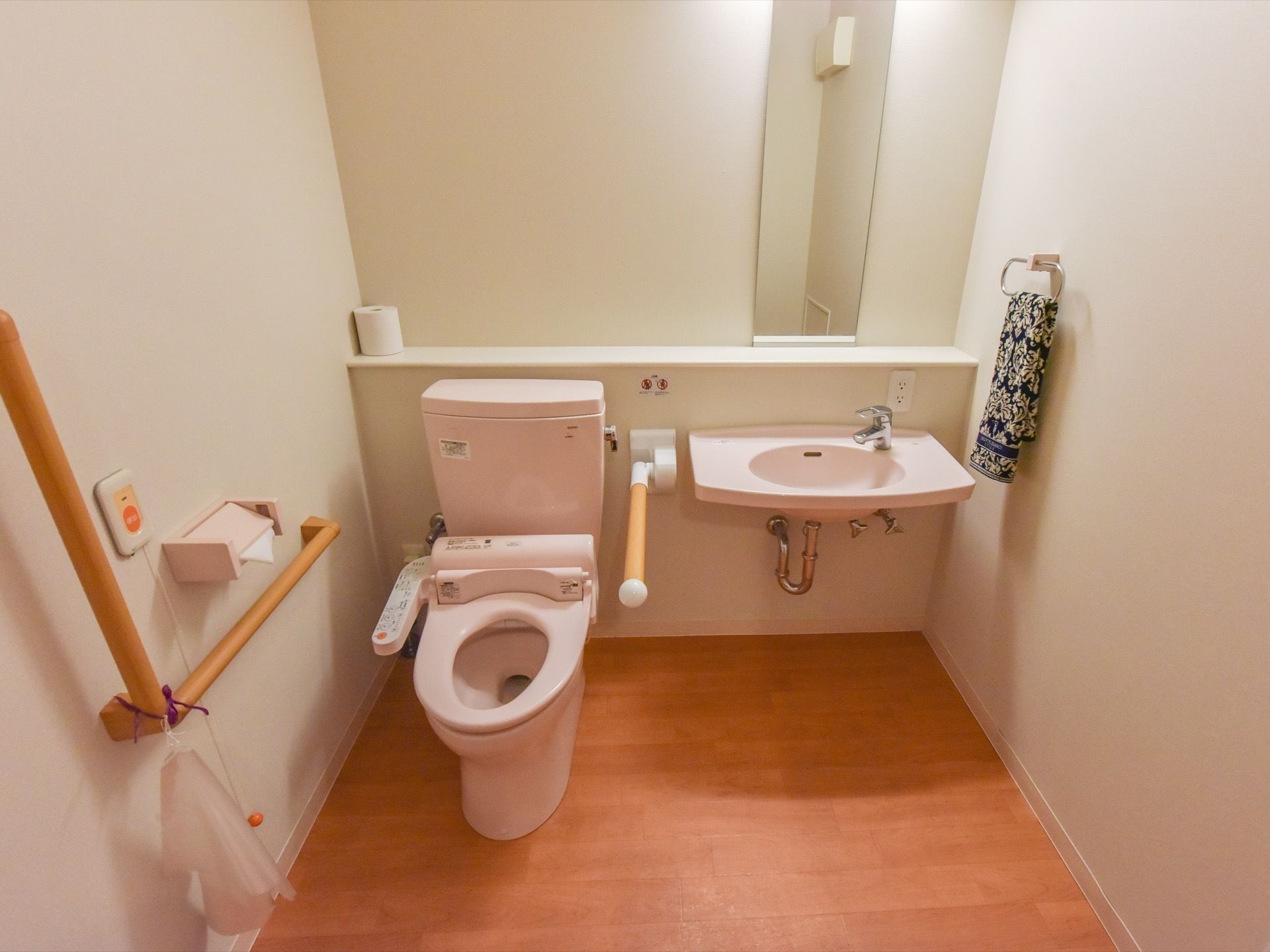 トイレは、便器・洗面台の周囲にスペースが多く取られ、車椅子での利用に配慮されている。便器と洗面台の間の手すりは可動式である。