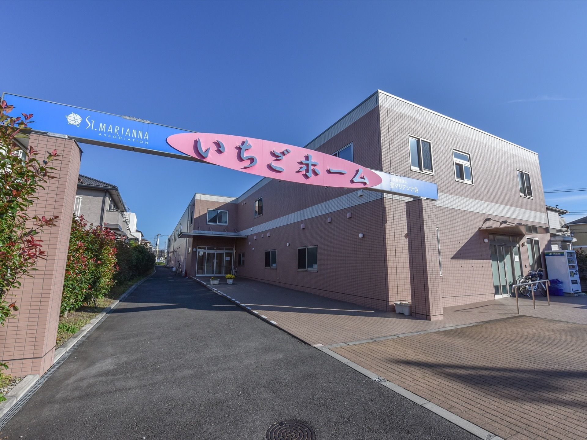 ２階建ての施設は茶色のレンガ張りの外観である。施設前には大きなゲートが設けられ、施設名が記されている。
