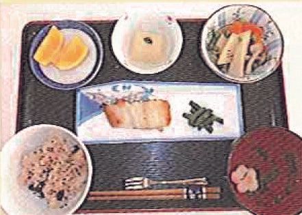 赤飯と吸い物とカットオレンジのデザートが付いたメニュー