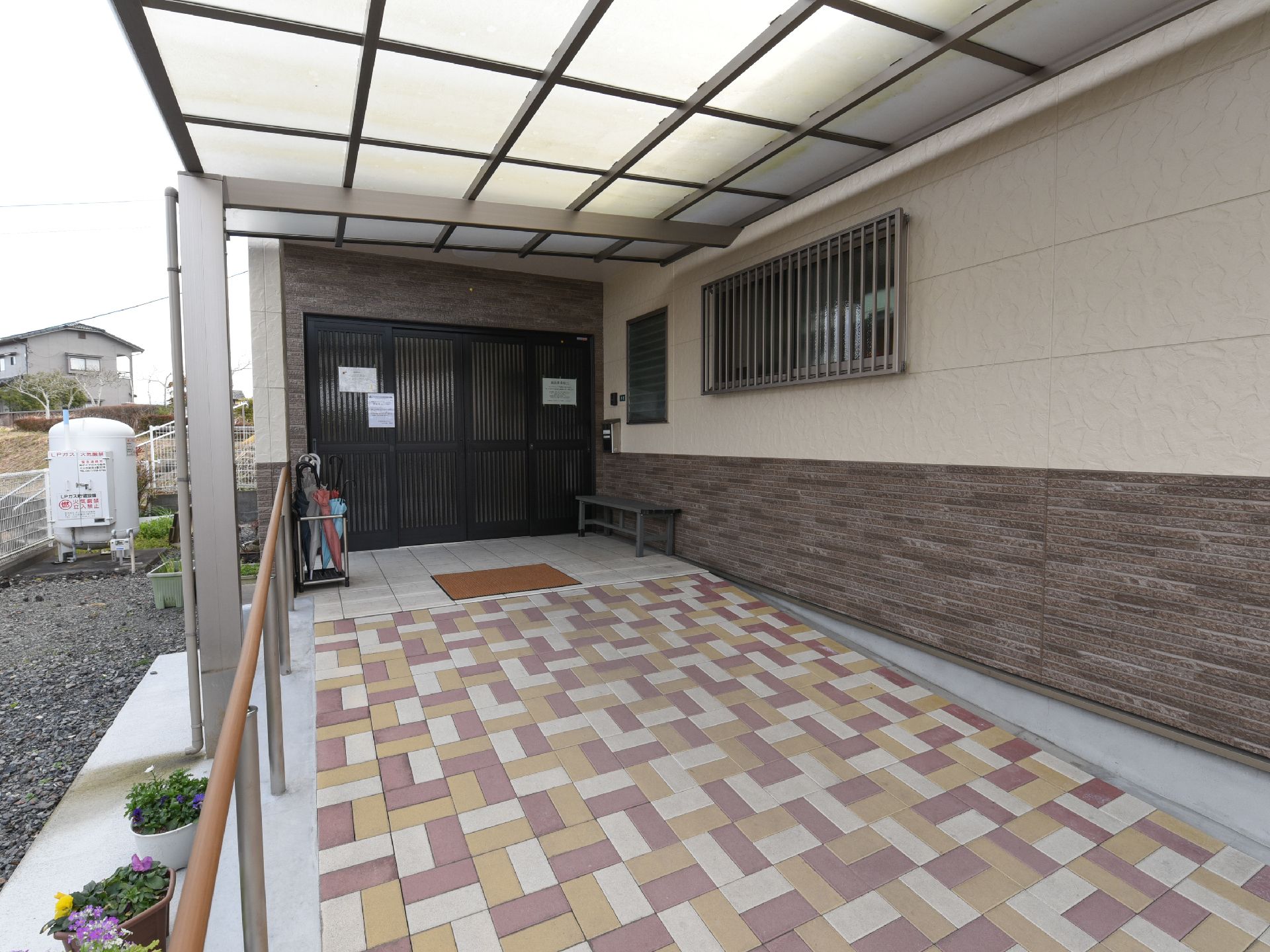 玄関の扉は開閉しやすいスライド式が用いられている。幅の広いスロープが設けられており、足腰に不安のある方にも楽に移動していただける。