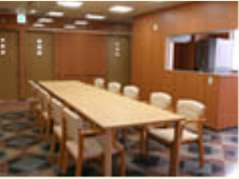 幾何学模様の床と白い椅子やテーブルがおしゃれな食堂