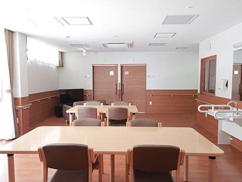 4人がけのテーブル2つが置かれた、テレビを観られる食事場所