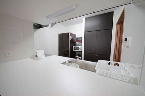 白や黒の家具家電でそろえられた、カウンター付きのキッチン