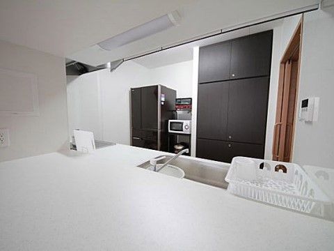白基調としたキッチンに並べられている、冷蔵庫と電子レンジなどの調理家電