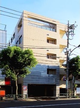 ベージュ色の外壁が目立つ、道路に面した5階建て施設外観