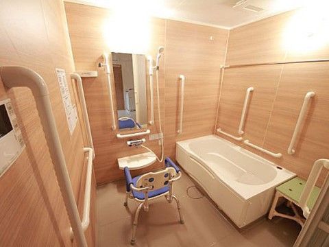 壁に多数の手すりが取り付けられ、2つの椅子が用意された浴室