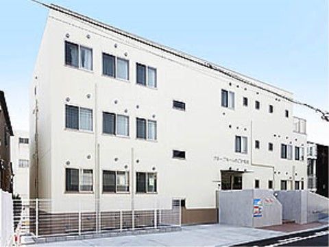 建物の前に駐車スペースがある、白壁のグループホーム外観