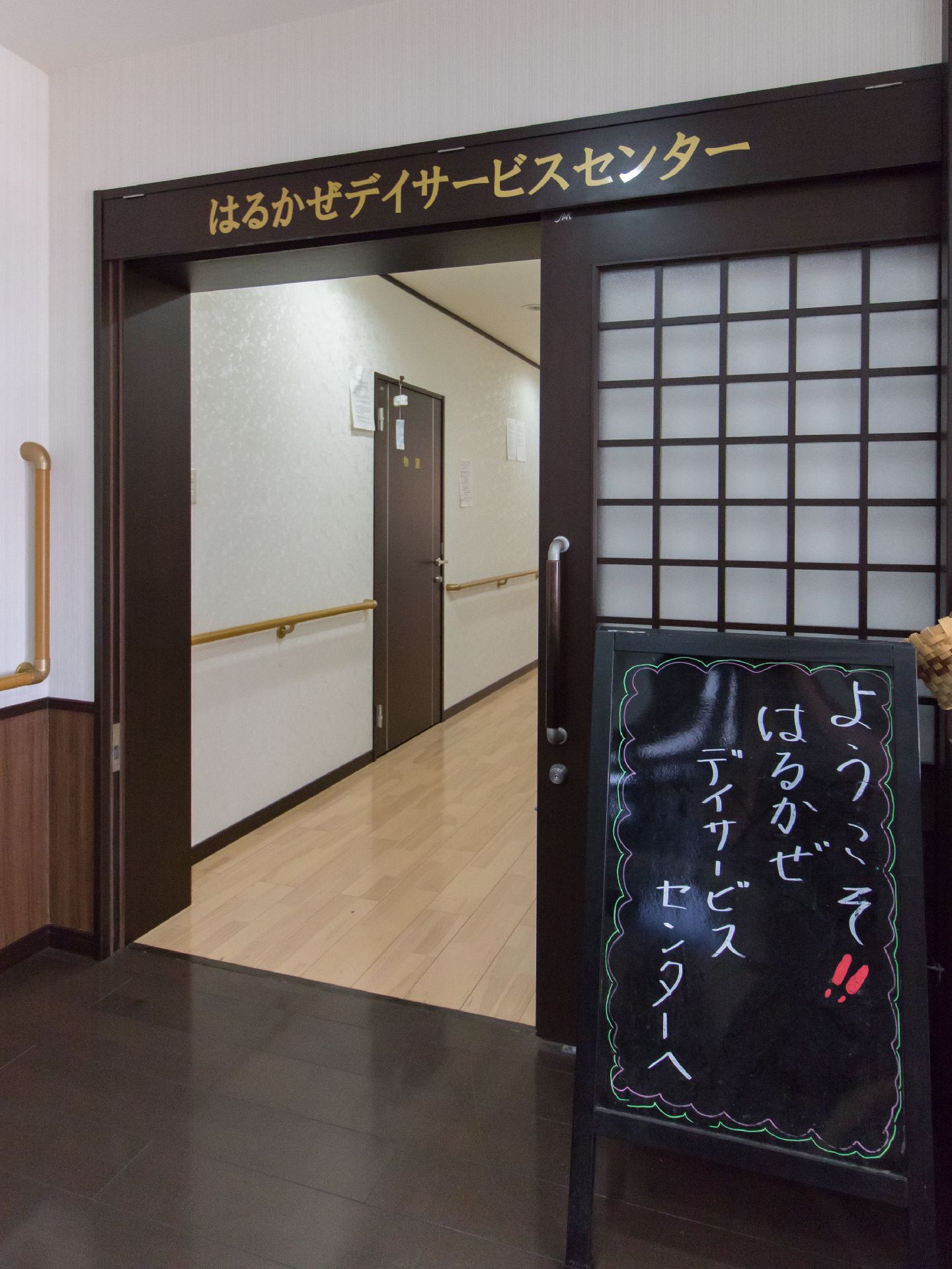 こちらの施設へようこそと書いてある看板が入口に置かれている。扉は引き戸になっていて、安全に開閉できる。