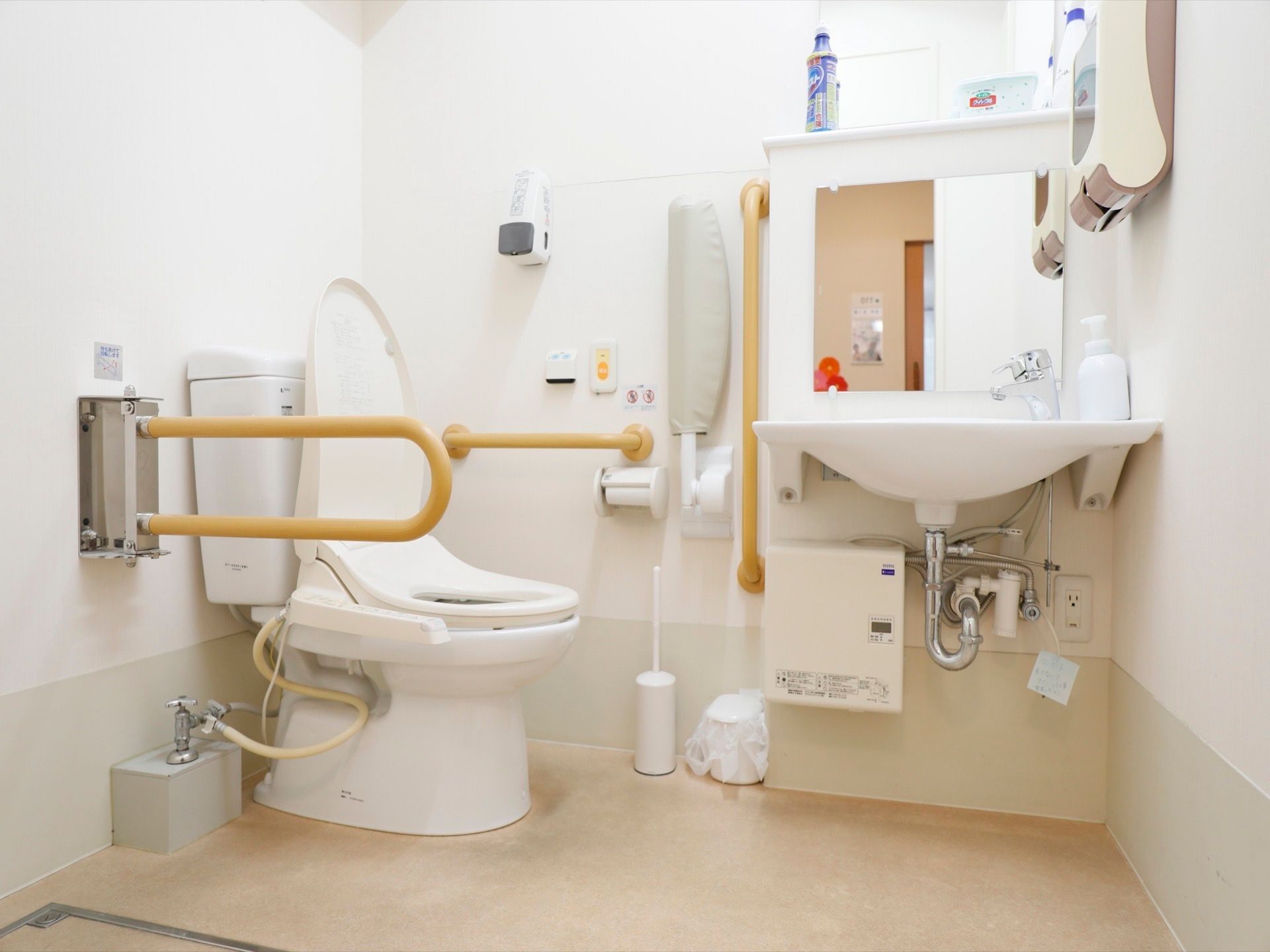 共用のトイレは広いスペースとなっている。便座横には手すりが設置され、立ち座りをスムーズに行える。洗面台も併設されている。