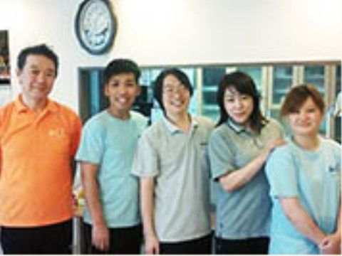 柔らかな笑顔で入居者様を迎えるポロシャツ姿のスタッフたち