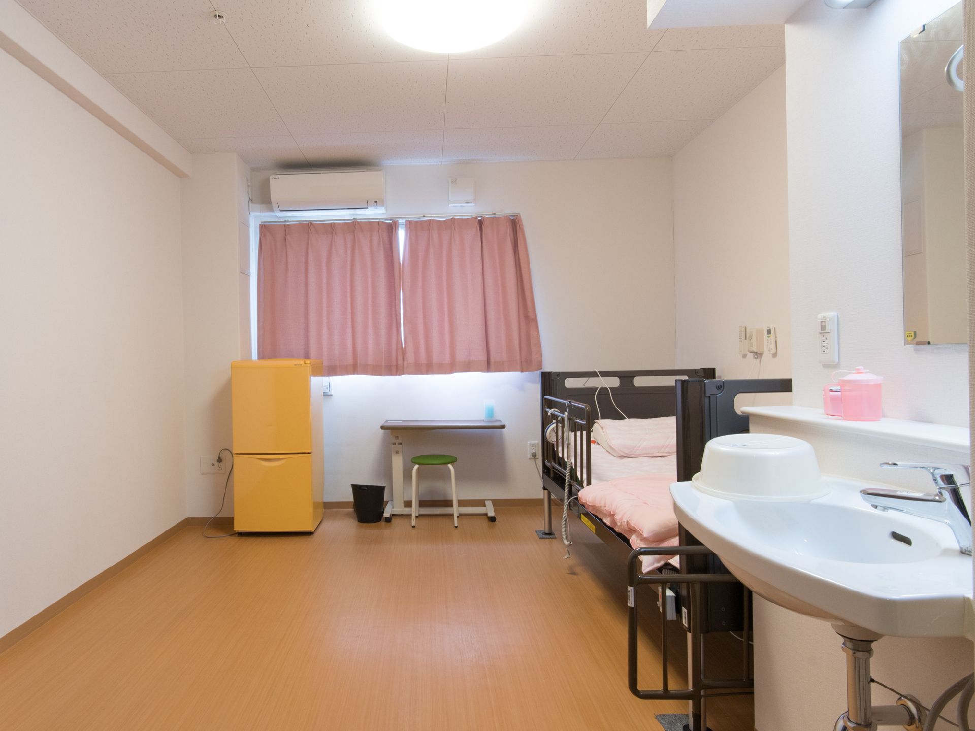 居室に備え付けのベッドは安全ガードを付け、壁には非常用のナースコールを設置。空いた空間には家具を置く等自由に使えるスペースを設けている。