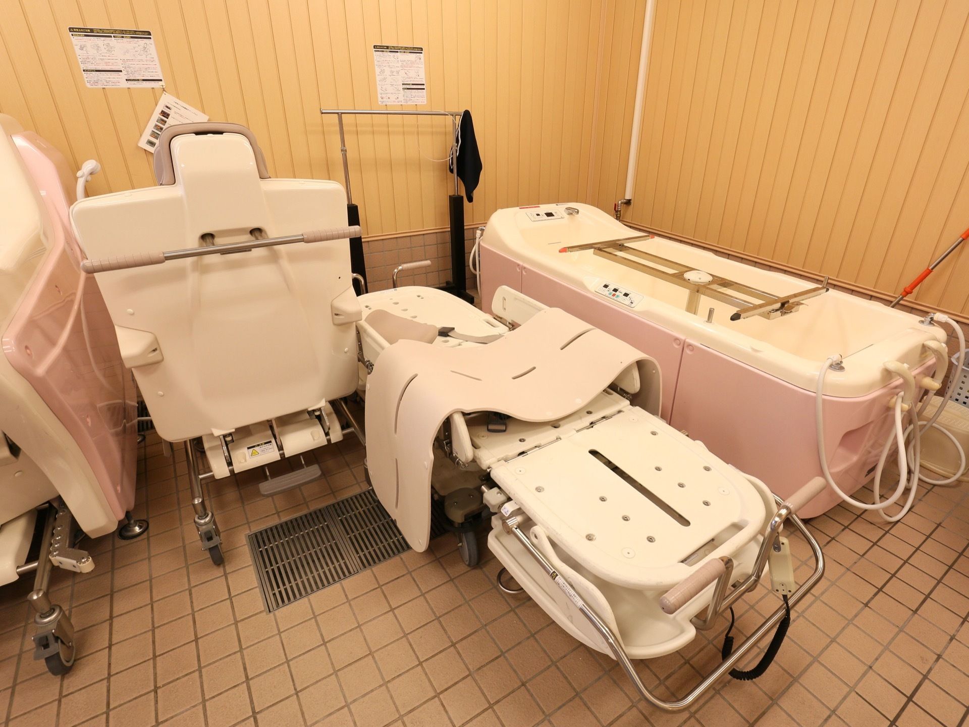 ストレッチャーに寝たままの状態で入ることがきる介護浴槽が設置されている。隣には、座った状態でお湯に浸かれる装置もある。