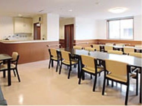 広々とした明るい空間の中に、多くの人が同時に食事できる、長テーブルとゆったりと座れるイスが置いてある。